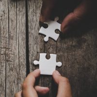 hand-connecting-puzzle-pieces-table-e1670094329203.jpg hand-connecting-puzzle-pieces-table-e1670094329203.jpg